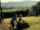 two kids playing on a toy tractor in a field