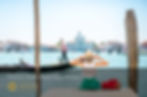 woman watching a gondola go by in venice italy